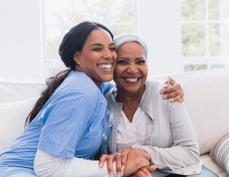 A caregiver hugs her senior client