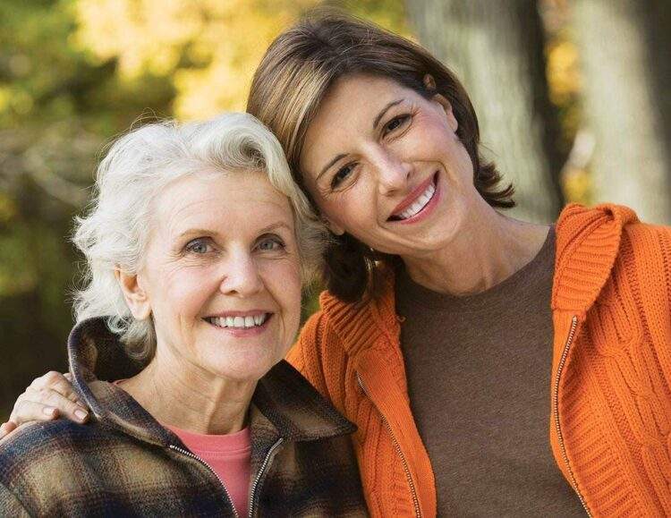 An adult daughter hugs her mother