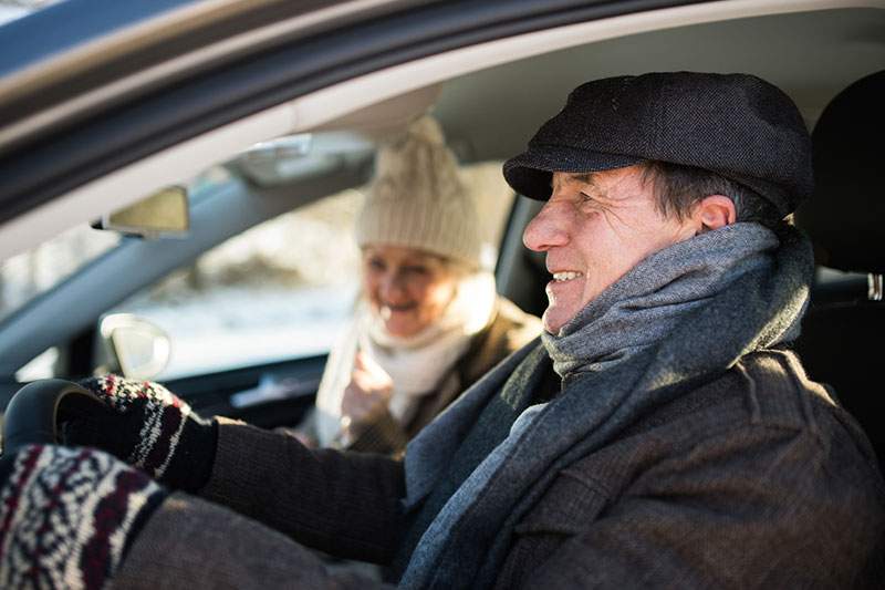 elderly couple driving a car