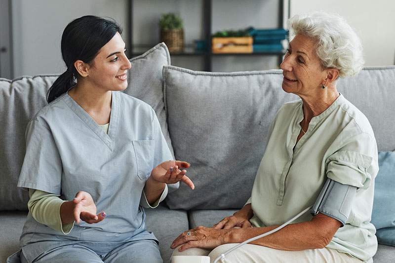 caregiver with elderly woman on the couch