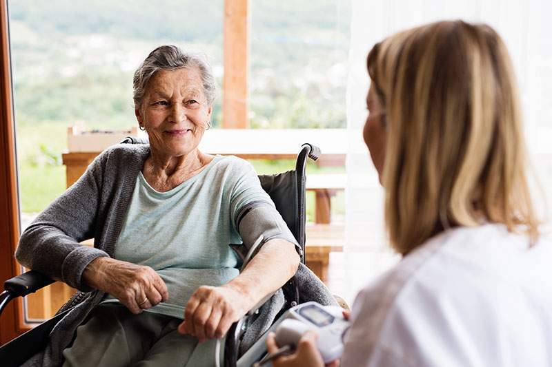 elderly women in wheelchair with caregiver