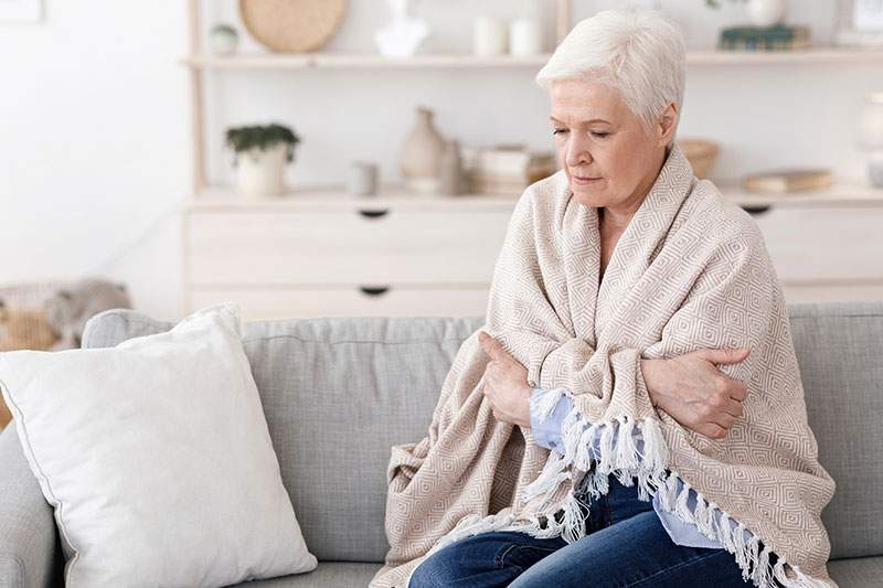 elderly women on the coach wrapped in blanket